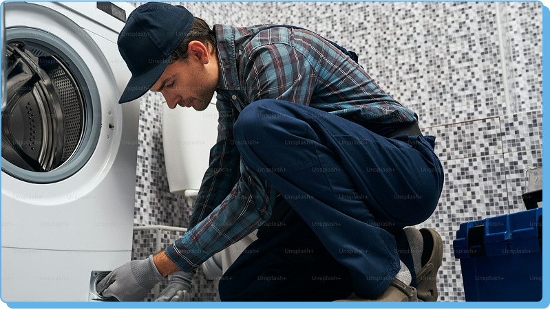 Technician repairing washing machine.