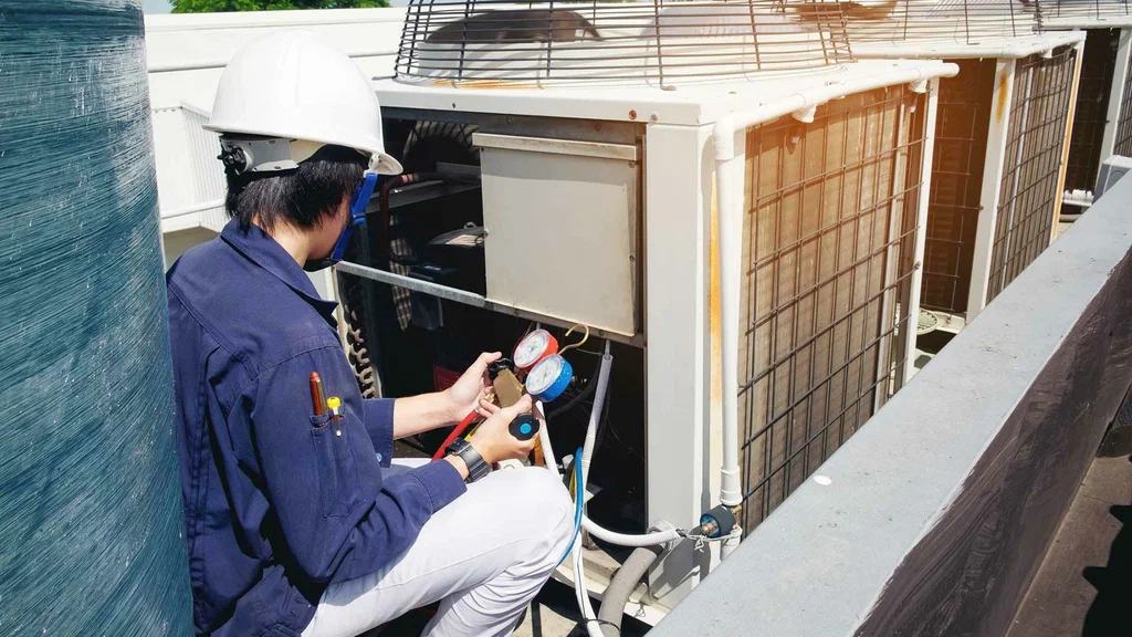 Air conditioner technician checking pressure with gauges