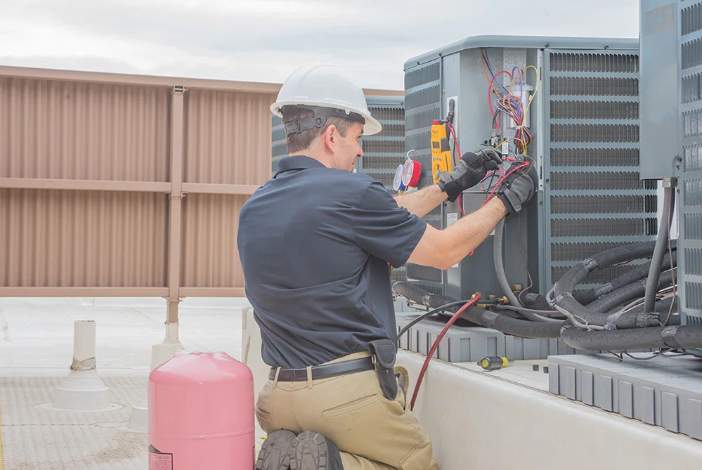 HVAC technician repairing air conditioning unit.