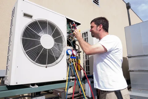 Technician servicing air conditioning unit outside