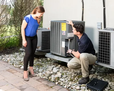 Technician explaining air conditioner to customer