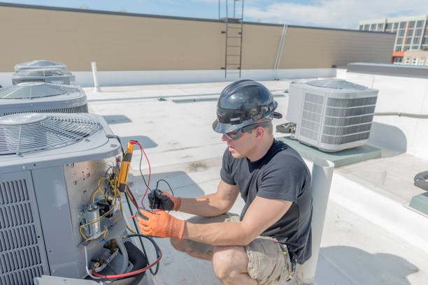 An HVAC technician inspecting and repairing an AC unit